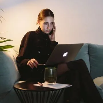 A woman at a laptop on the phone