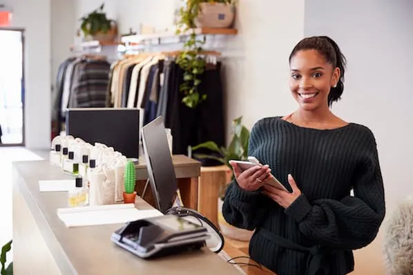 Woman at a cash register holding a tablet