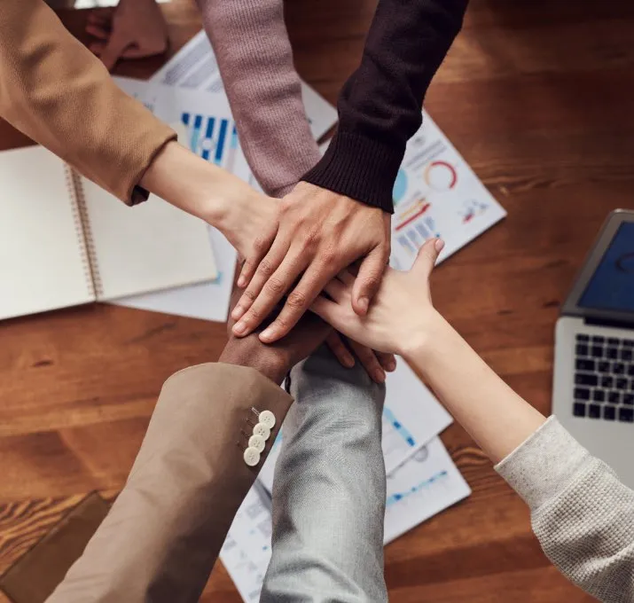 Six people together with hands on top