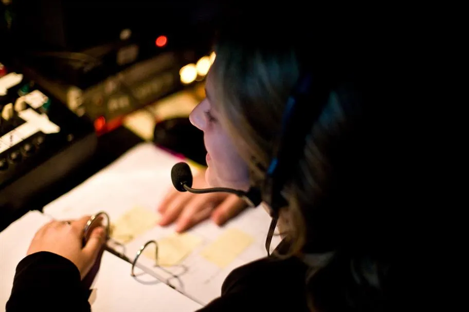 Stage manager coordinating talent and performers backstage at a live event